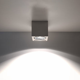 White square ceramic ceiling light fixture turned on, showing the focused light beam below.