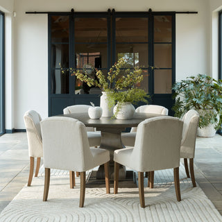 Stone apple ornament displayed on a round dining table with cream chairs in a bright conservatory setting.