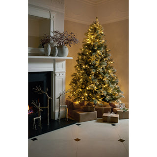 Stone effect penguin statue on a mantelpiece in a cosy living room decorated for Christmas.