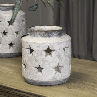 Close view of the stone-effect ceramic lantern showing star cutouts illuminated by a light source inside.