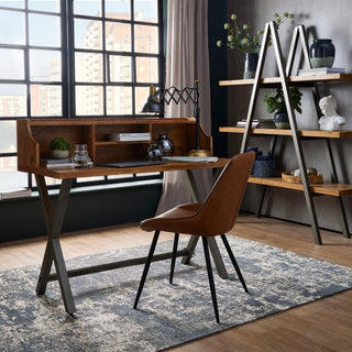 Tan faux leather chair used as a desk chair in an industrial-style home office setting.