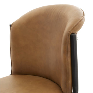 Detail of the tan leather backrest side seam and connection point with the black metal frame support.