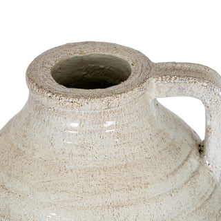 Detail shot showing the rustic cream glaze texture, the jug's rim, and the attached handle.