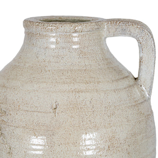 Close up of the ceramic jug's upper body, showing the neck, rim, and the curved handle attachment.