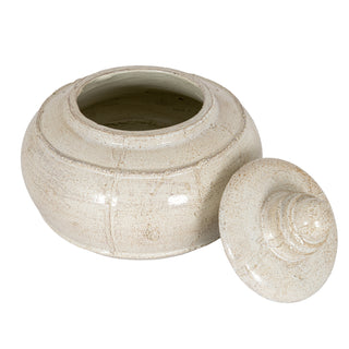 Distressed cream decorative pot shown open, with the round lid resting next to it.
