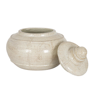 Distressed cream pot, open, revealing the interior rim, with the round finial lid leaning against the body.