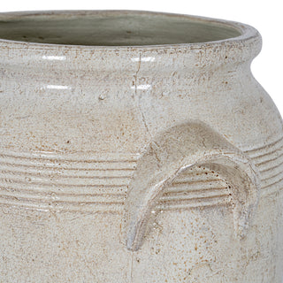 Rustic detail of the pot's handle and upper body, showing the mottled off-white finish and incised lines.
