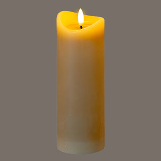 Full view of the tall taupe LED candle showing the warm glow around the melted top edge.