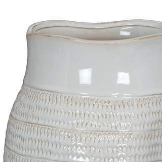 Close detail of the white vase showing the smooth glaze transitioning into the textured body pattern.
