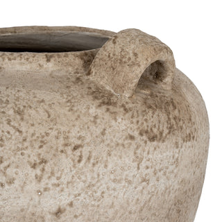 Close-up detail of the mottled beige ceramic texture and one curved loop handle near the vase rim.
