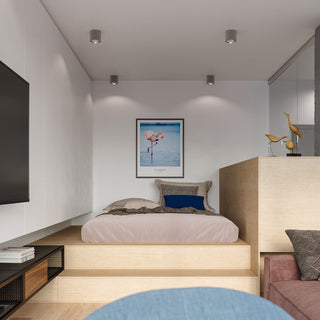 Four grey ceiling spotlights installed above a raised bed platform in a compact, modern studio bedroom.