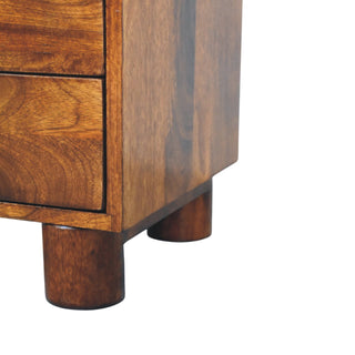 Detail of the nightstand's base and short, cylindrical wooden feet.