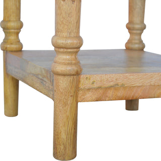 Detail of the lower shelf, short feet, and turned vertical support leg.
