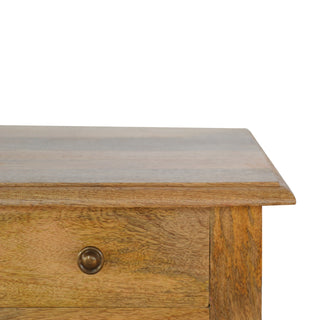 Detail of the telephone table's wooden grain, top edge profile, and circular brass drawer handle.