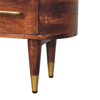 Curved corner of the dark wood media unit resting on tapered legs with brass caps.