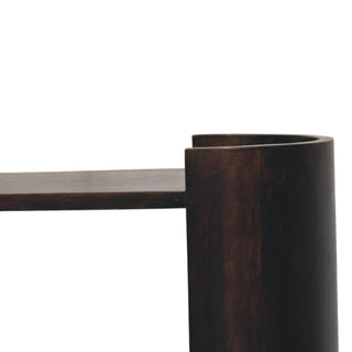 Detail of the dark wood finish where the flat shelf meets the curved cylindrical support.