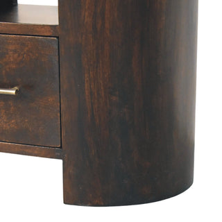 Close up of the dark wood grain and curved cylindrical side panel near the base of the bedside table.
