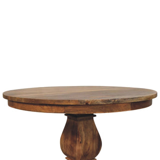 Low-angle view of the wooden tabletop's thick edge and the bulbous, turned upper section of the central pedestal base.