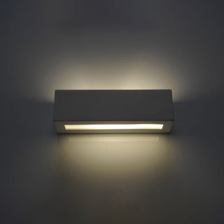 Straight-on view of the illuminated ceramic wall lamp showing the light wash above and below.