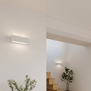 Two ceramic wall lamps installed in a modern stairwell setting with white walls and wooden steps, highlighting the textured finish.
