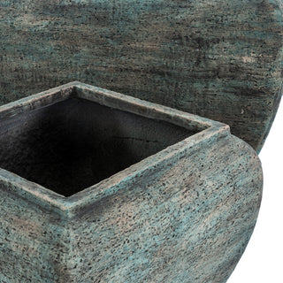 Detail shot showing the heavily textured surface and distressed green patina of the two planters overlapping.