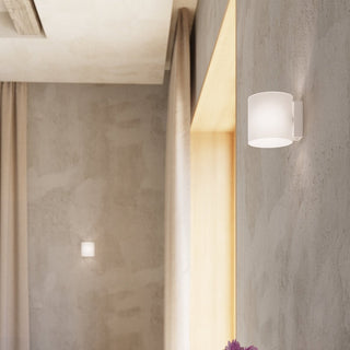 VICI wall light installed near a wooden trim, showing the fixture in context with a smaller background wall lamp.