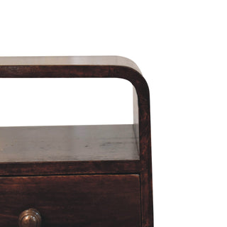 Close-up detail of the dark walnut bedside table showing the curved top edge and open storage slot.