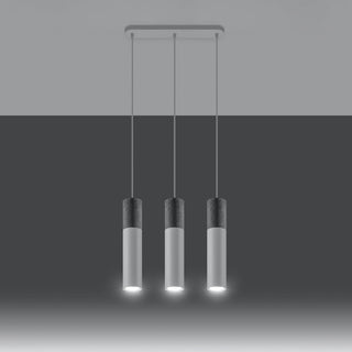 Three cylindrical pendants illuminated, highlighting the downward light source and textured concrete tops.