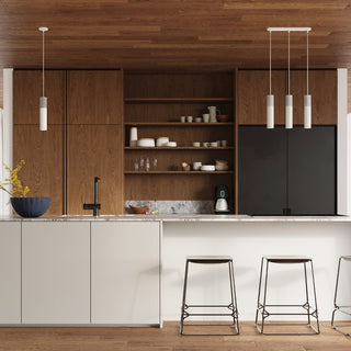 Three-light pendant installed over a kitchen island in a modern room with wood ceiling and cabinets.