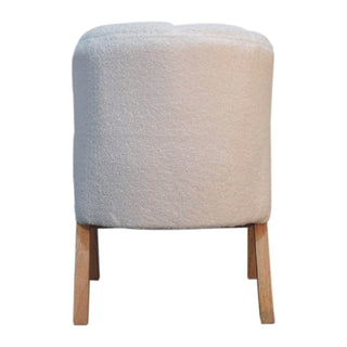 Full rear view of the white boucle chair showing the curved, fully upholstered backrest and exposed wooden legs.