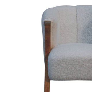 Close-up detail of the white boucle texture and the exposed wooden frame joint.