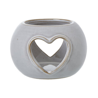 Round ceramic tealight holder with a rustic grey-white glaze and a large heart-shaped opening cut out on the front.