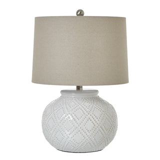 White ceramic squat table lamp with textured base and neutral linen shade. Front-on studio shot.