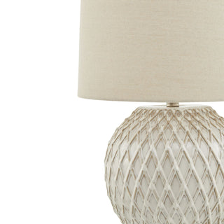 Close-up showing the raised lattice texture of the white ceramic base and the neutral fabric shade.
