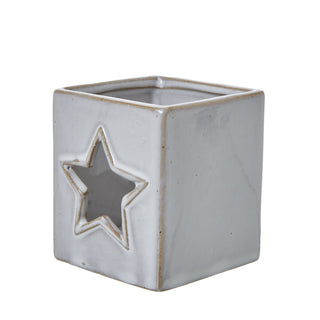 Glazed white ceramic tealight holder viewed from an angle, showing the square shape and star aperture.