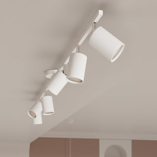 Linear white track light fixture with multiple cylindrical spotlights mounted on a ceiling.