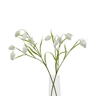 Artificial white fritillaria stem in a clear glass vase base against a white background.