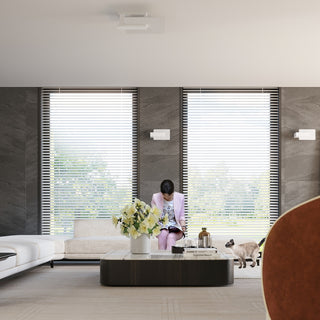 Wall lamps installed symmetrically on a dark grey tiled wall in a modern living room setting.