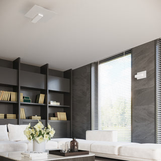 Wall lamp and matching ceiling light in a modern living room with dark grey tiled walls and white seating.