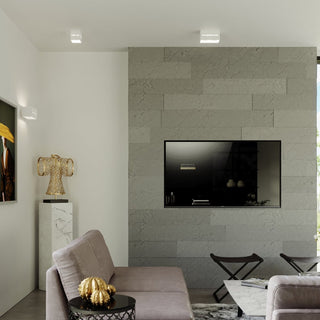 White cubic wall light installed on both the wall and ceiling in a modern living room.