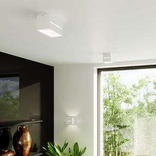 Three white cubic lamps installed as both wall lights and surface-mounted ceiling spotlights.