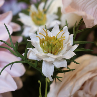 Close detail of the artificial white nigella bloom centre, shown mixed with blurred pink and cream faux flowers.