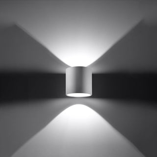 White ORBIS wall lamp showing the wide, directional light beams shining upwards and downwards.