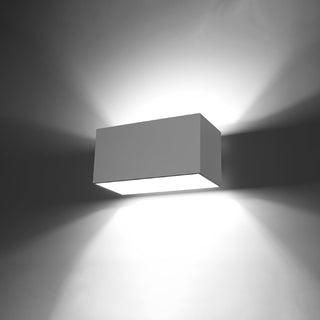 Rectangular wall lamp demonstrating its upward and downward light distribution on a dark wall.