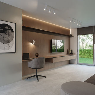 White wall lamp installed above a floating wooden desk, complementing the recessed lighting and ceiling spotlights.