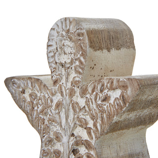 Extreme close-up on the angel's head and wings, highlighting the deeply carved texture and distressed white wash.