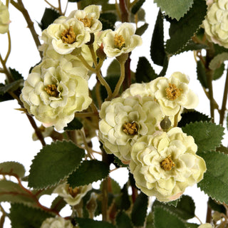 Detail of artificial green meadow rose cluster, showing textured petals, buds, and serrated leaves.