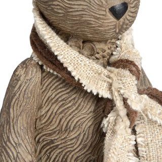 Close up detail of the rabbit sculpture's textured body and the rustic brown and cream striped scarf tied around its neck.