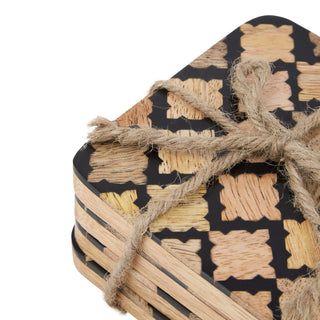 Close up of the black geometric pattern, wood texture, and rough brown rope knot binding the coasters.