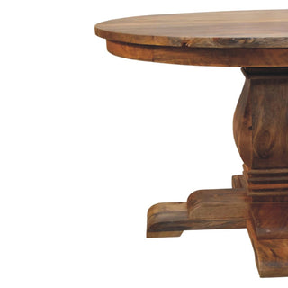 Close-up showing the curved edge of the wooden tabletop and the substantial turned base and foot.